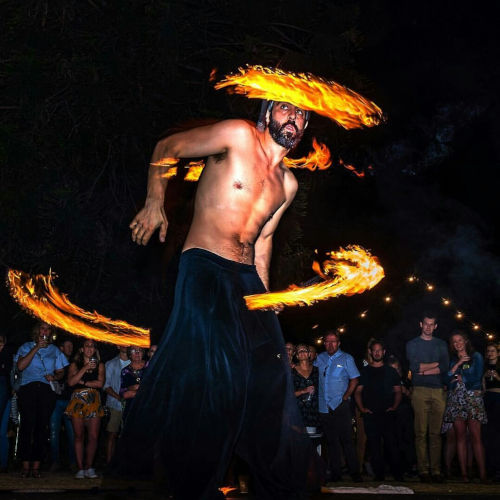 Into the fire: Miguel Rubio, nighttime scene, fire juggling with vibrant colors. Shows of Collectif Primavez