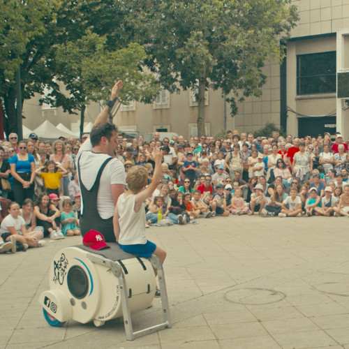 ImproLocura est un spectacle de théâtre physique. Luca Della Gatta. Agro the clown saluant avec un spectateur enfant, avec le public en arrière-plan